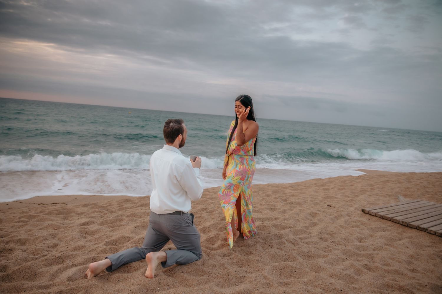Private couple date and photoshoot on the open coast of Badalona Beach under a warm, glowing sunrise sky