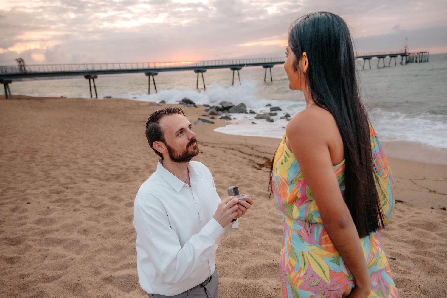Candid couple walking along the peaceful water's edge at Badalona Beach during a quiet morning love session