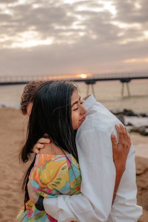 Bubbly engagement photoshoot on Badalona Beach featuring a happy laughing couple near the calm sea waves