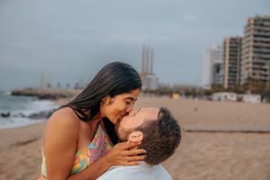 Romantic couple gazing at the Mediterranean sunrise on Badalona Beach for an authentic, unscripted photo session