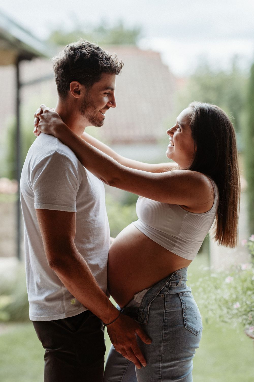 une femme enceinte et le futur papa qui se regardent en souriant