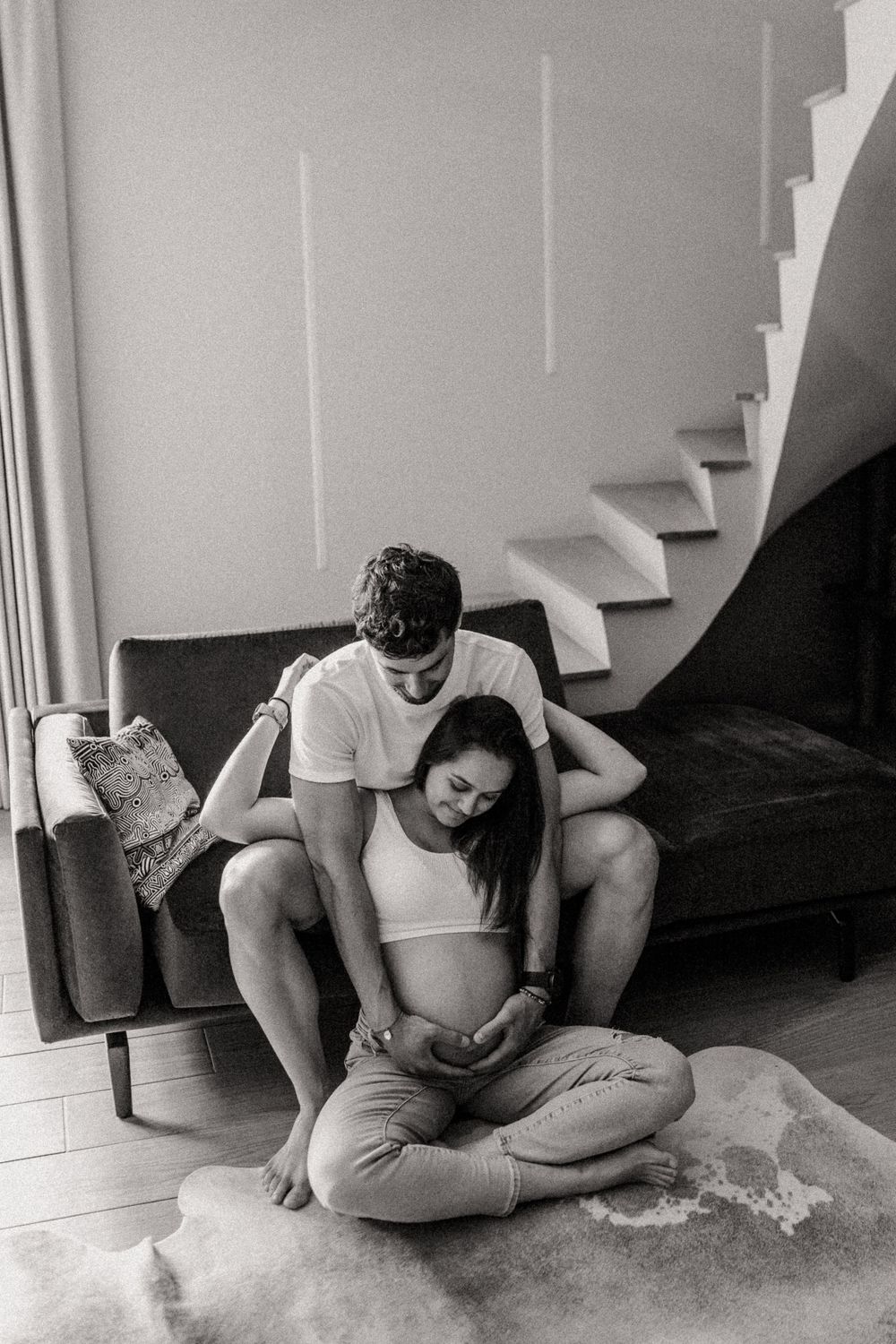 photo en noir et blanc en intérieur d'un couple de futurs parents