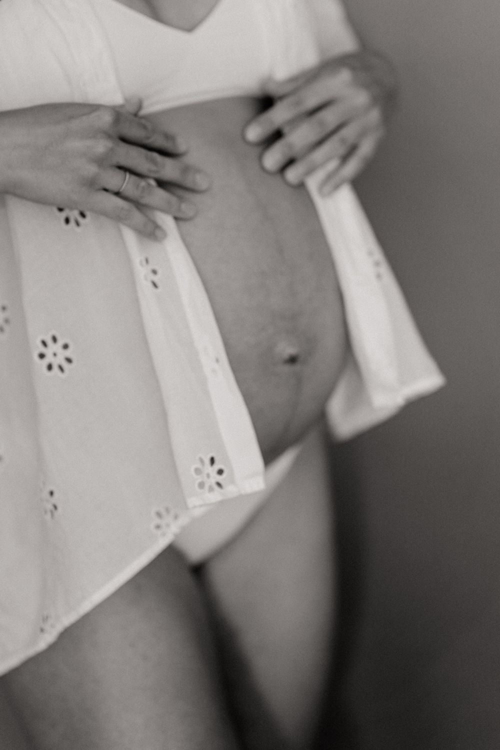 photo en noir et blanc d'une femme enceinte qui touche son ventre