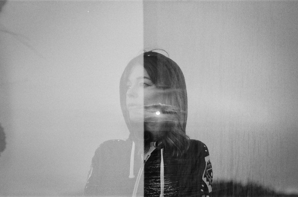 Double exposure monochrome photograph merging architectural elements with natural textures in ethereal composition.