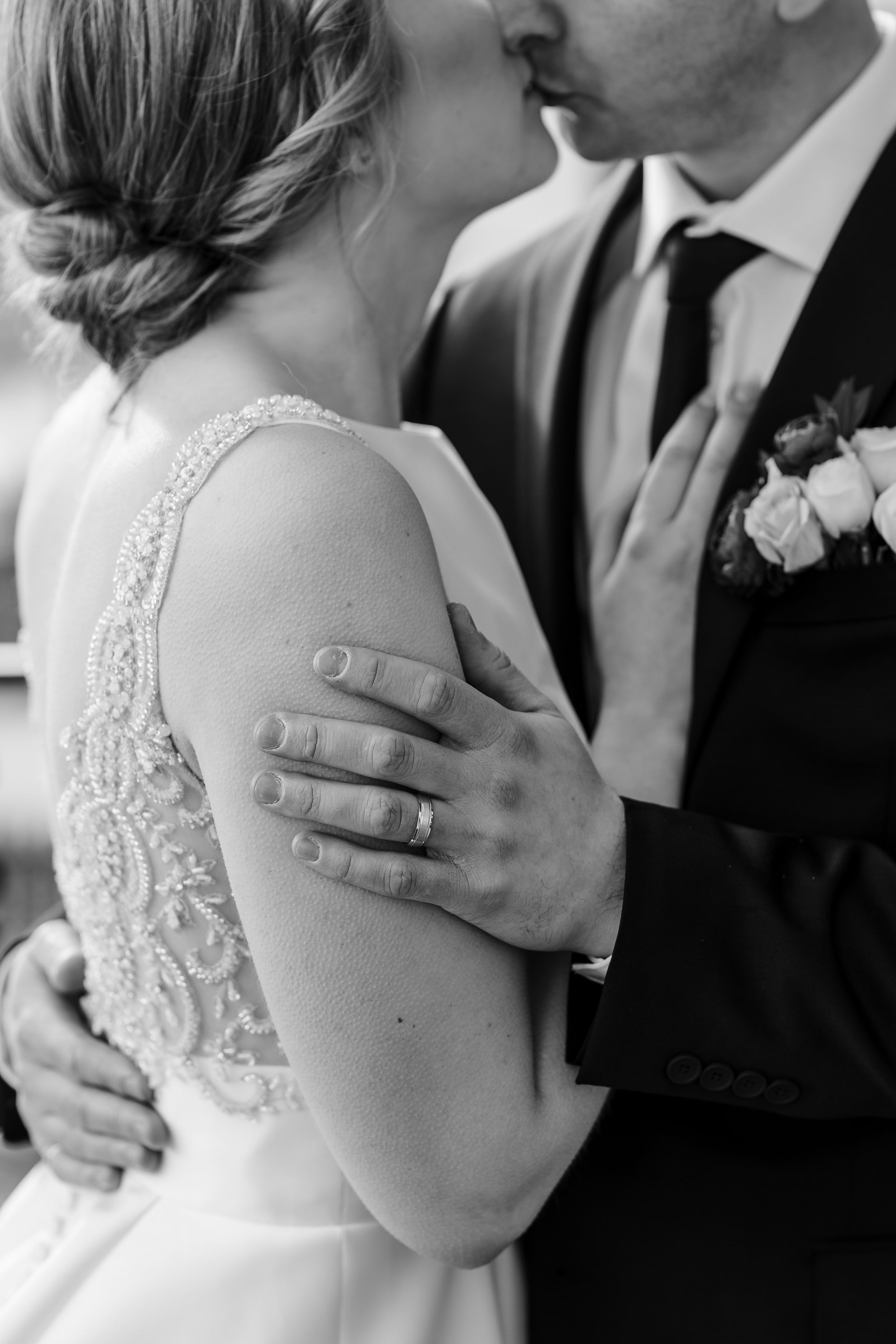 Black and white close-up photo of newlyweds sharing an intimate moment during their first dance at a wedding reception.