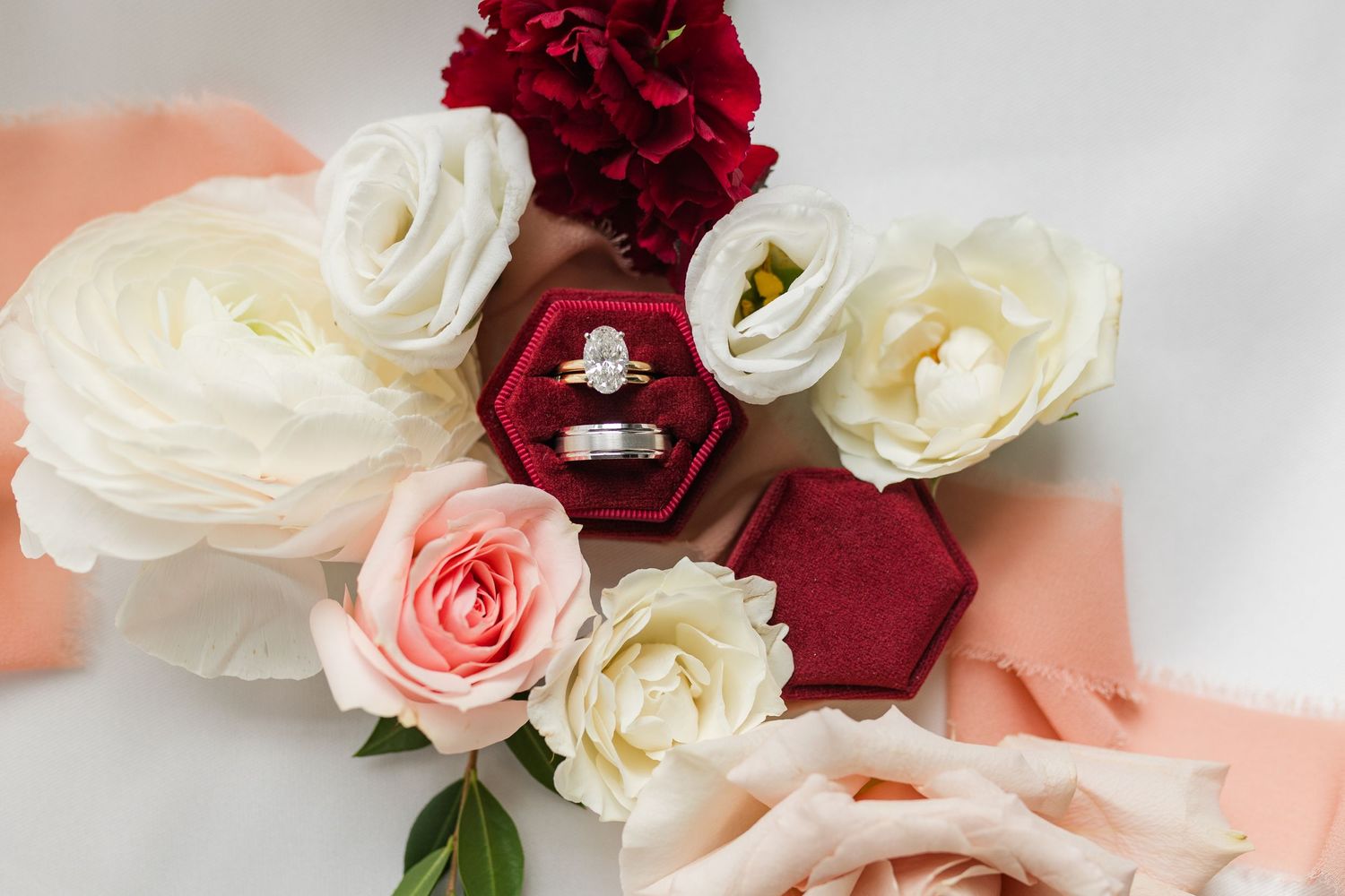 Elegant red and white roses arranged in a floral pattern with soft pink accents against a light background.