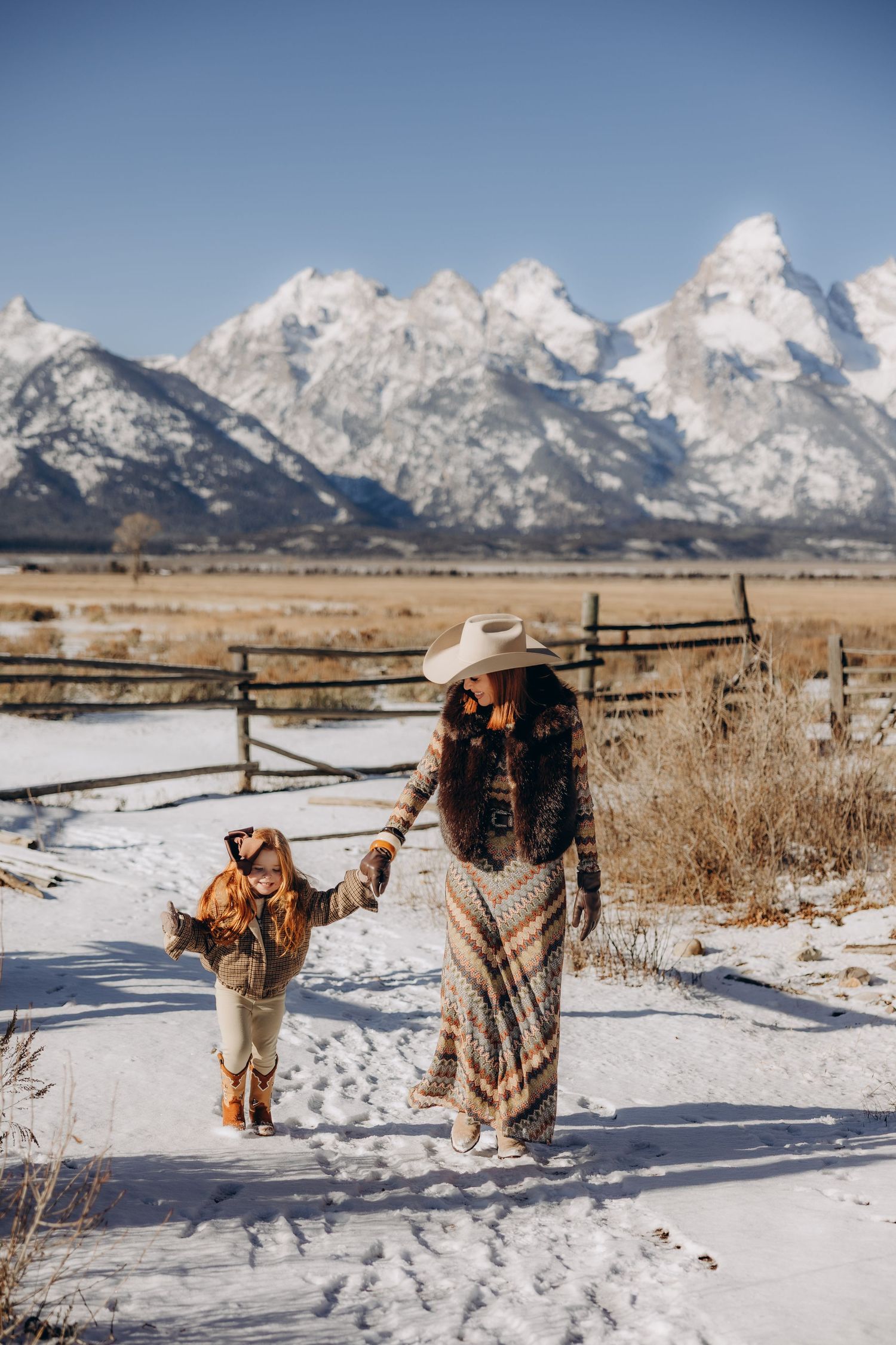 A winter scene in Grand Teton National Park with snow-covered ground and majestic mountain peaks in the background.