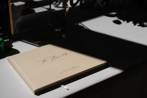A series of five photographs showing a book or album lying on a surface in different lighting conditions.