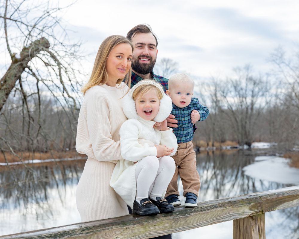 Family at winter family portrait photoshoot at Old North Bridge in Concord,MA by Lisa West Photography. Serving Metrowest of Boston.