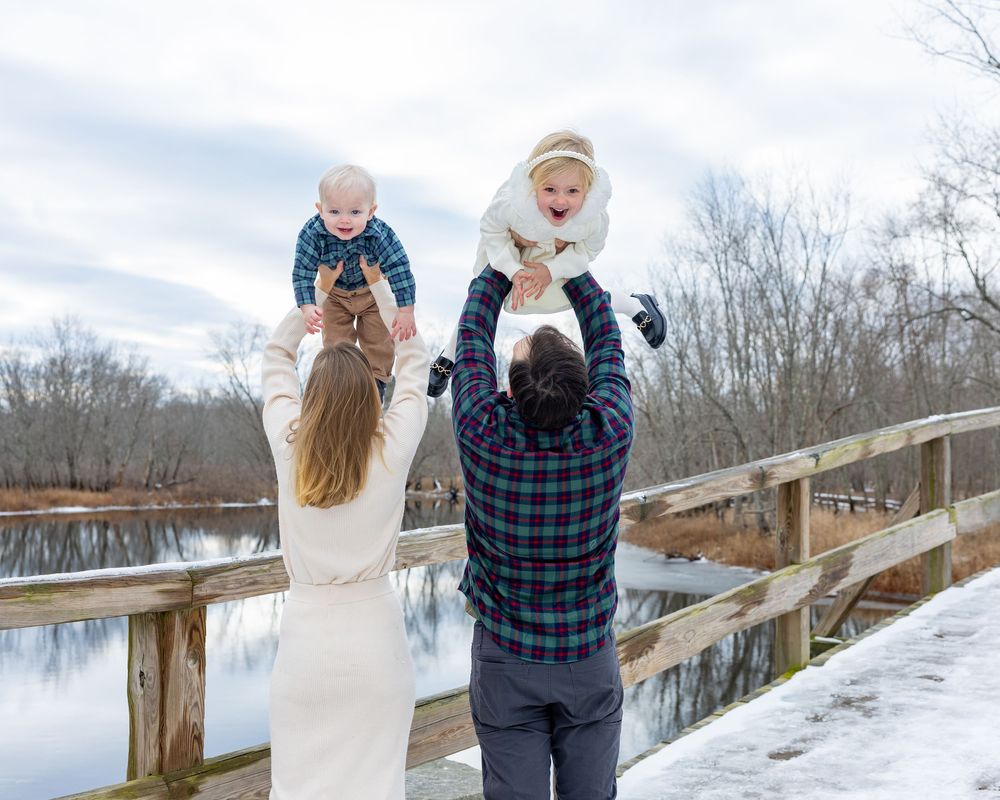 A family poses candidly during winter family photos in Concord, MA by Lisa West Photography.  Serving Metrowest of Boston area and Boston.