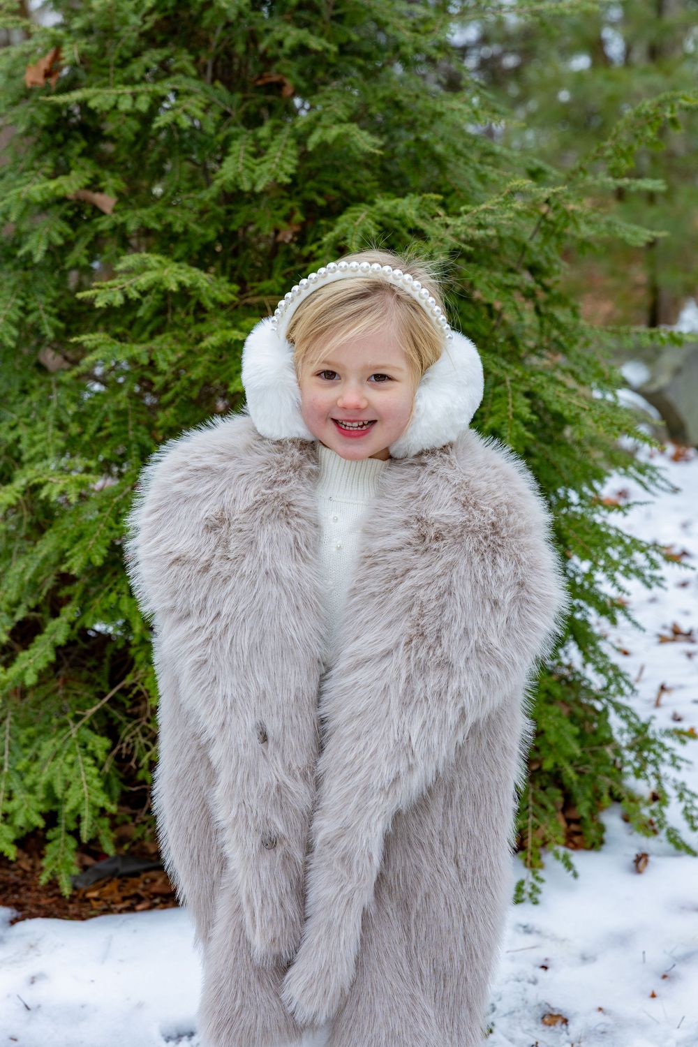 A toddler in a fur coat during winter family photos in Concord, MA by Lisa West Photography.  Serving Metrowest of Boston area and Boston.