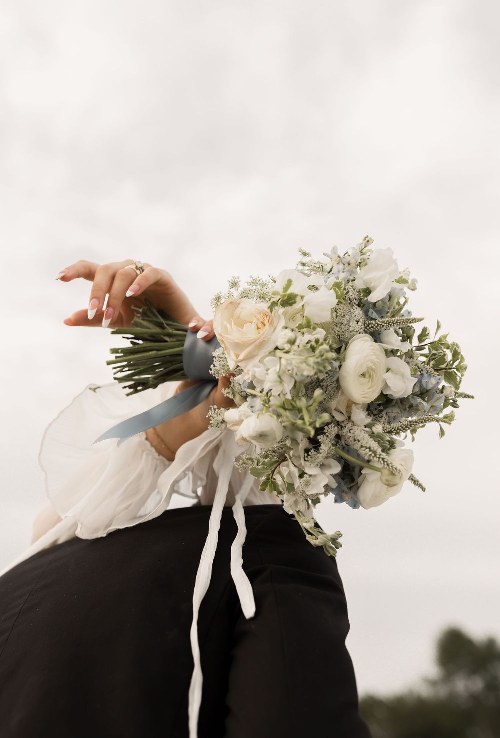 Four sequential photos showing hands holding a cascading white bridal bouquet with delicate ribbons against a dark background.