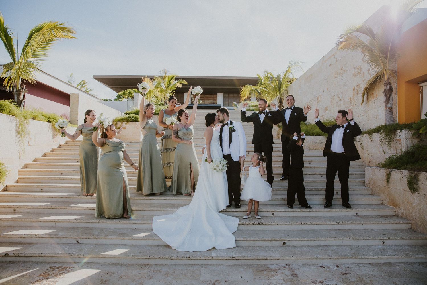 Elegant wedding ceremony setup with palm trees and white exterior walls in the background.