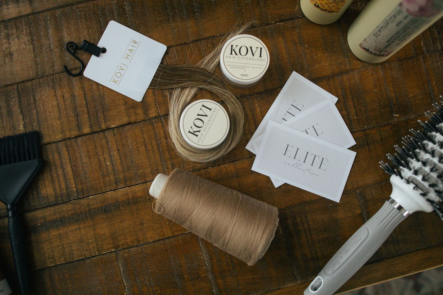 Stylish flatlay of office supplies and coffee on rustic wooden desk with notebooks and sewing thread.