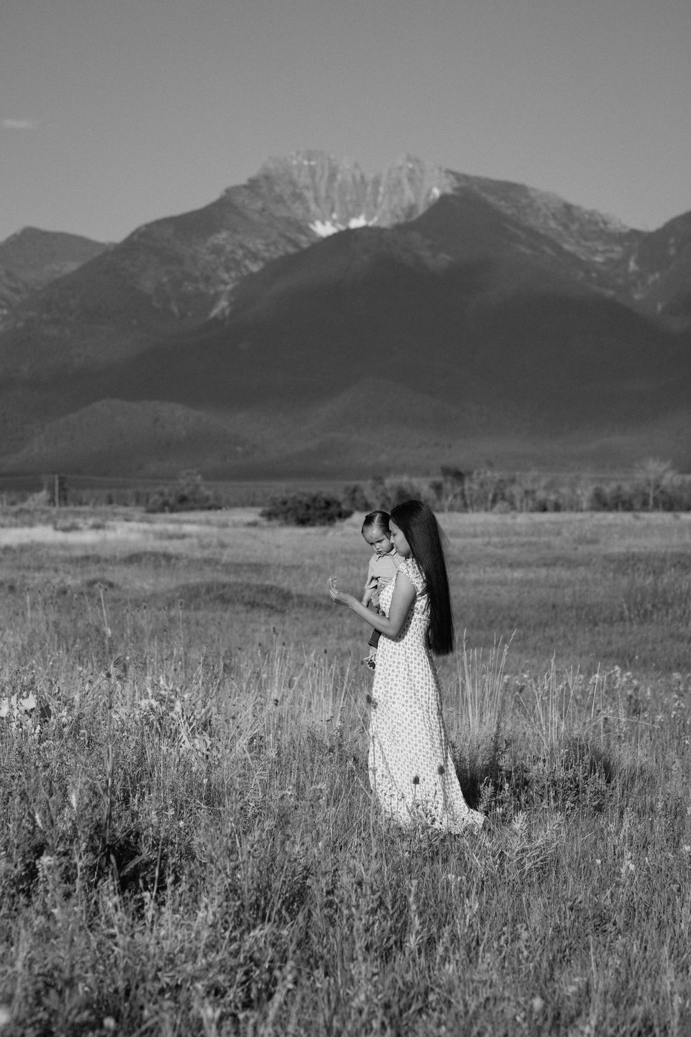 Black and white photo of a mountain landscape with wildflowers in the foreground.