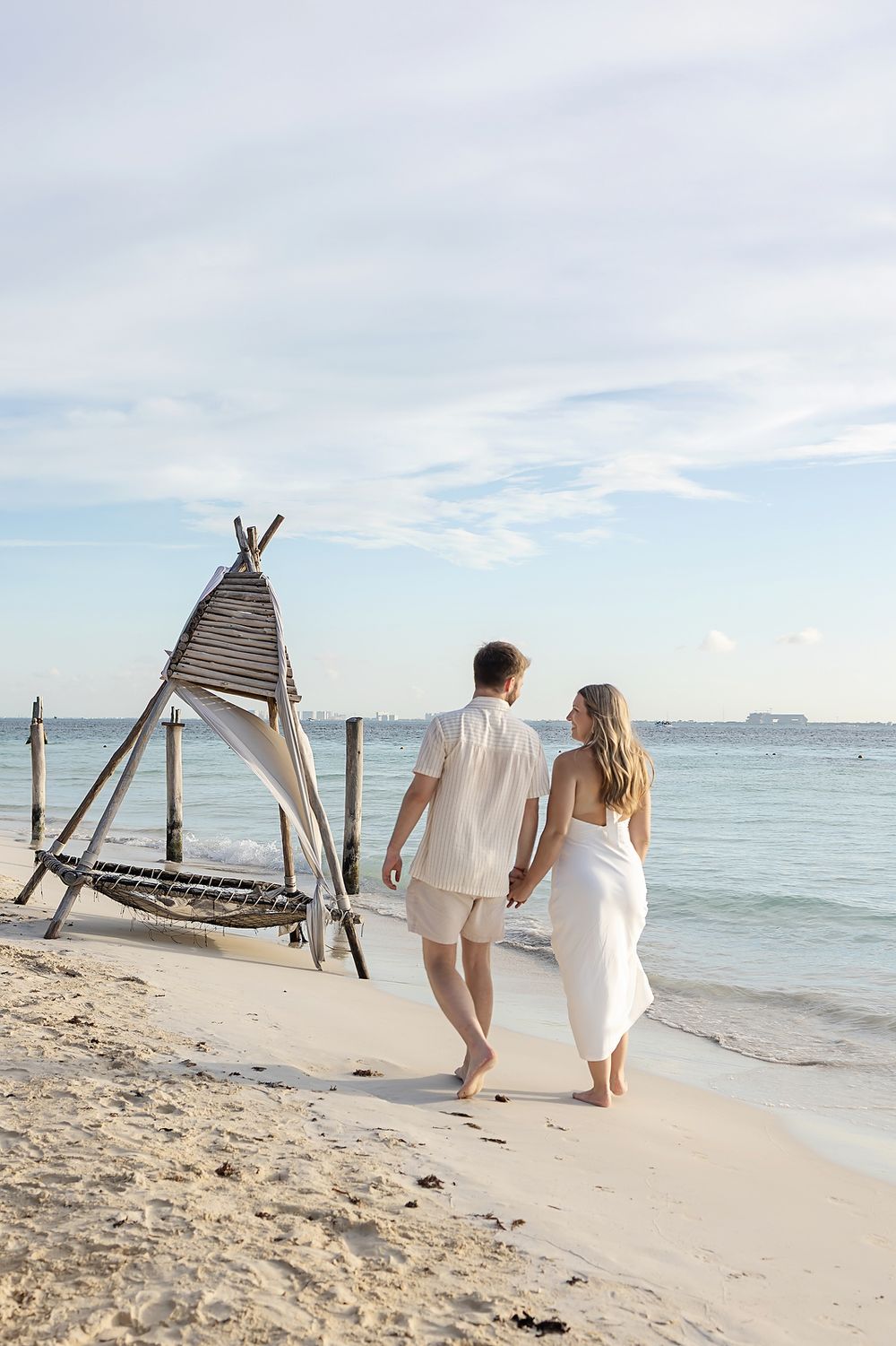 Couple walking along the coast at Playa Norte, Isla Mujeres during proposal photo shoot.