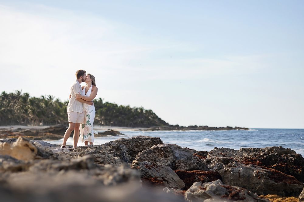 Romantic kiss at rocky shore during engagement session in Isla Mujeres, Mexico