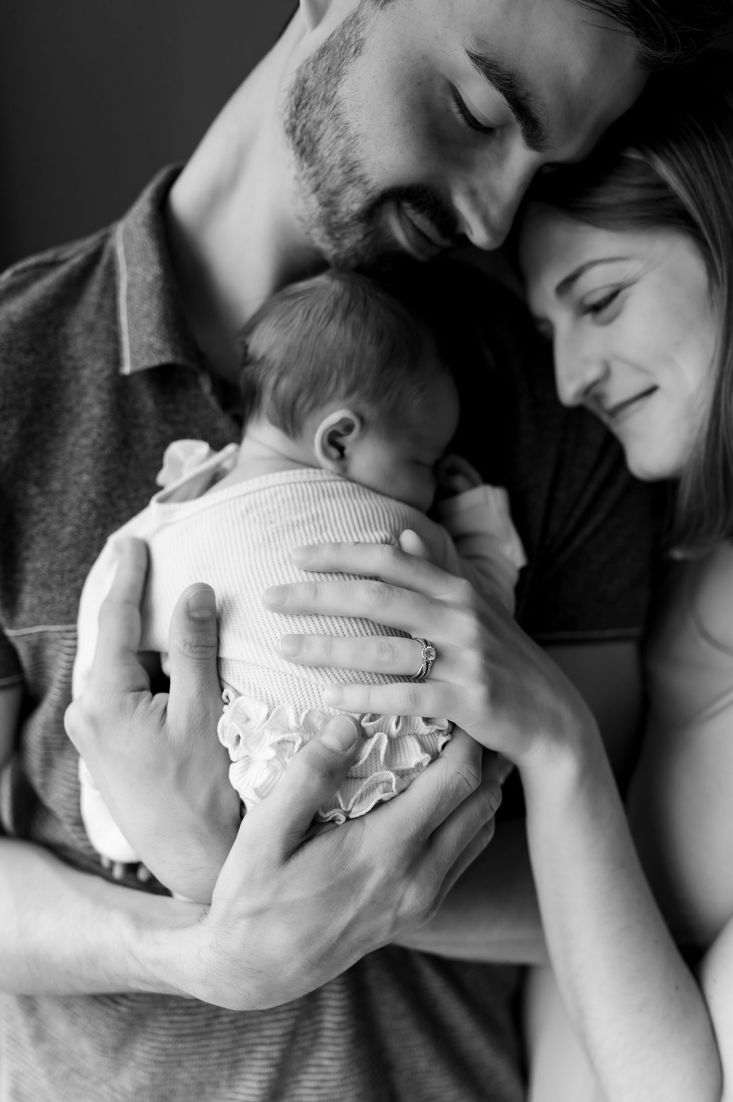 Black and white intimate photos of a sleeping newborn being cradled by parents created by Storms Photography in Pennsylvania.