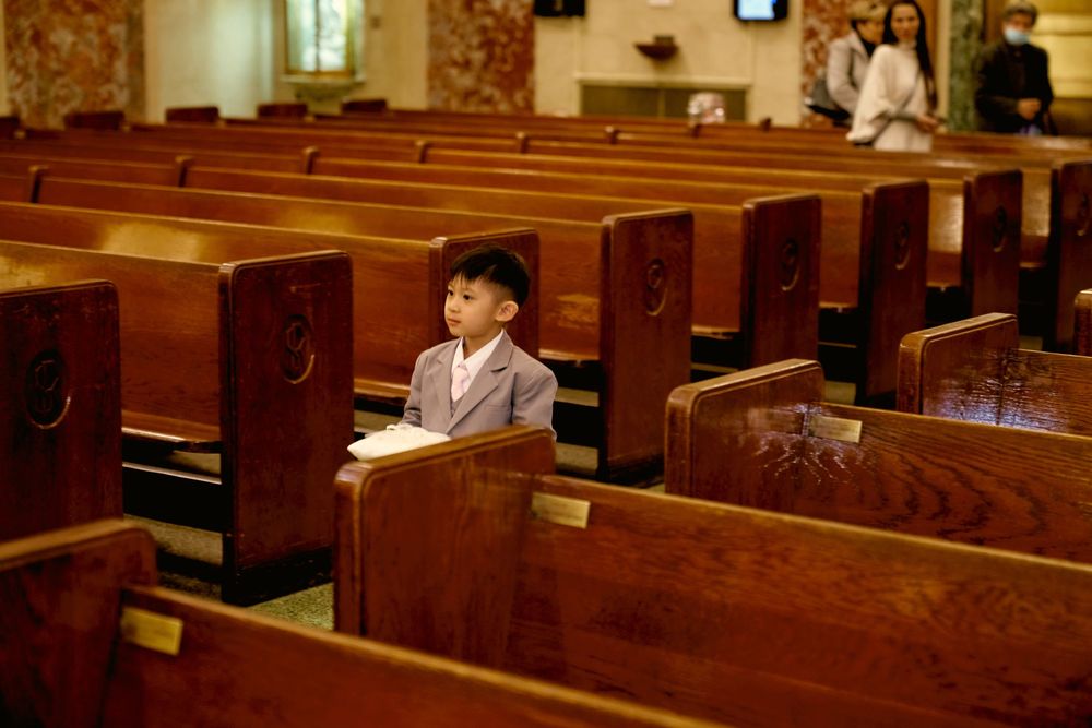 Empty wooden church pews arranged in rows inside a tranquil sanctuary.