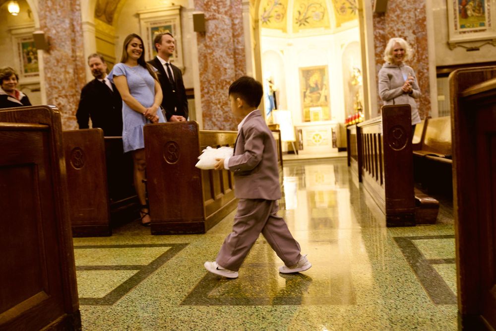 Church interior with marble columns and wooden pews during a ceremony.