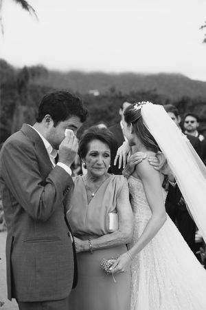 Black and white wedding photos showing candid emotional moments during a ceremony outdoors.