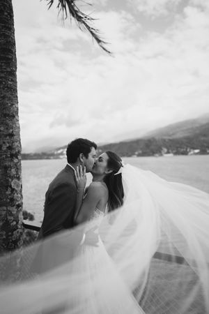 A romantic beach wedding photography sequence with a flowing veil catching the wind against a tropical oceanfront backdrop.