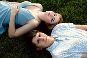 friends lying in green grass wearing casual summer clothing during a peaceful moment outdoors. Dfw Senior Session with friend
