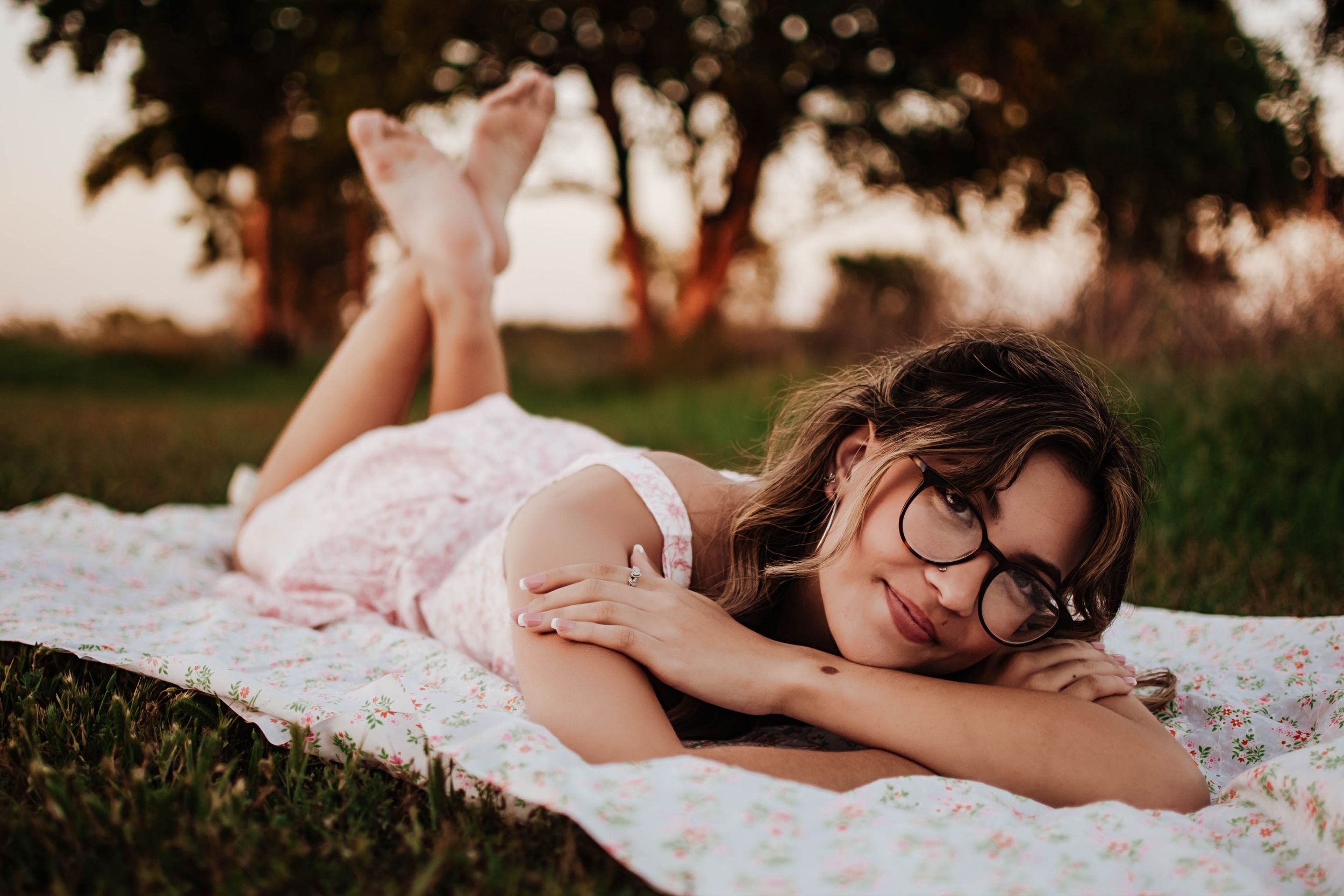 A dreamy outdoor photo of someone lying on a white blanket at sunset. Tandy Hills