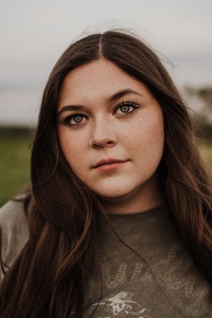 A close-up portrait shot against a natural outdoor background at dusk.  Dfw Senior Session with friend