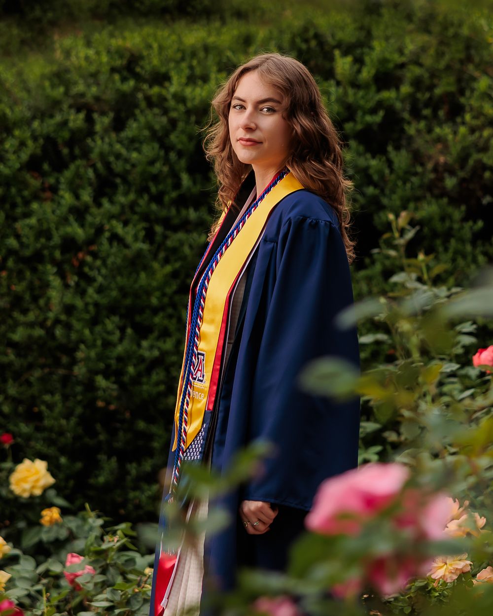 University of Arizona grad pictures with cap and gown on campus – UArizona graduation pictures at Old Main with flowers UofA portraits