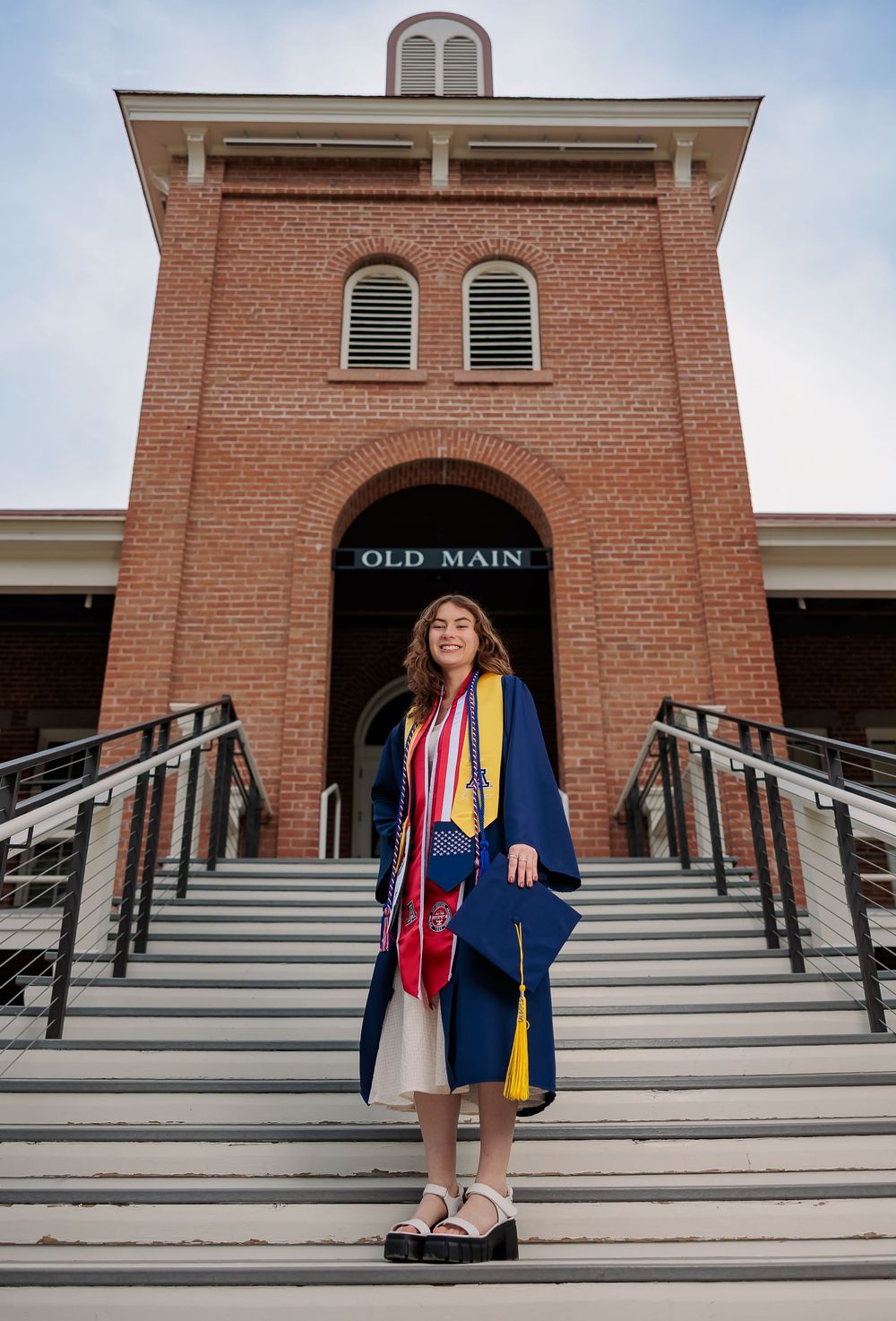 University of Arizona grad with cap and gown on campus – UArizona graduation pictures at Old Main