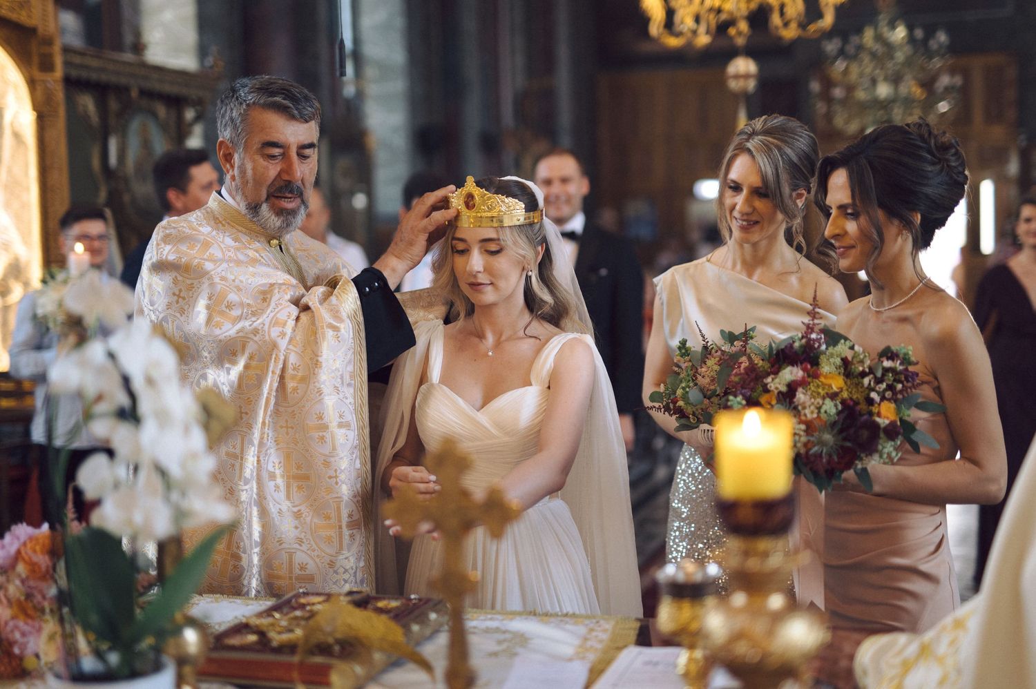 Orthodox wedding ceremony in a church with candles and floral decorations as part of the traditional service.