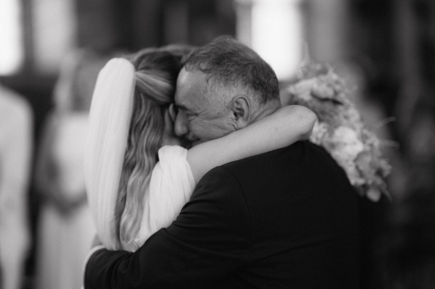 A series of six black and white candid wedding photos showing romantic moments and embraces during a celebration.