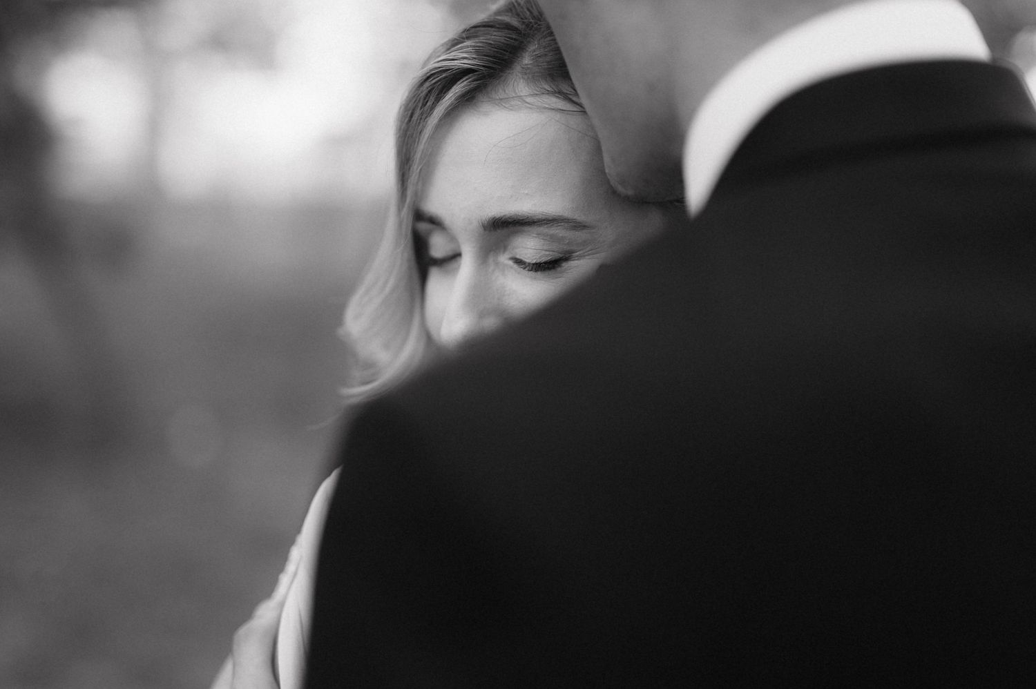 A romantic black and white close-up photo of newlyweds sharing a tender moment.