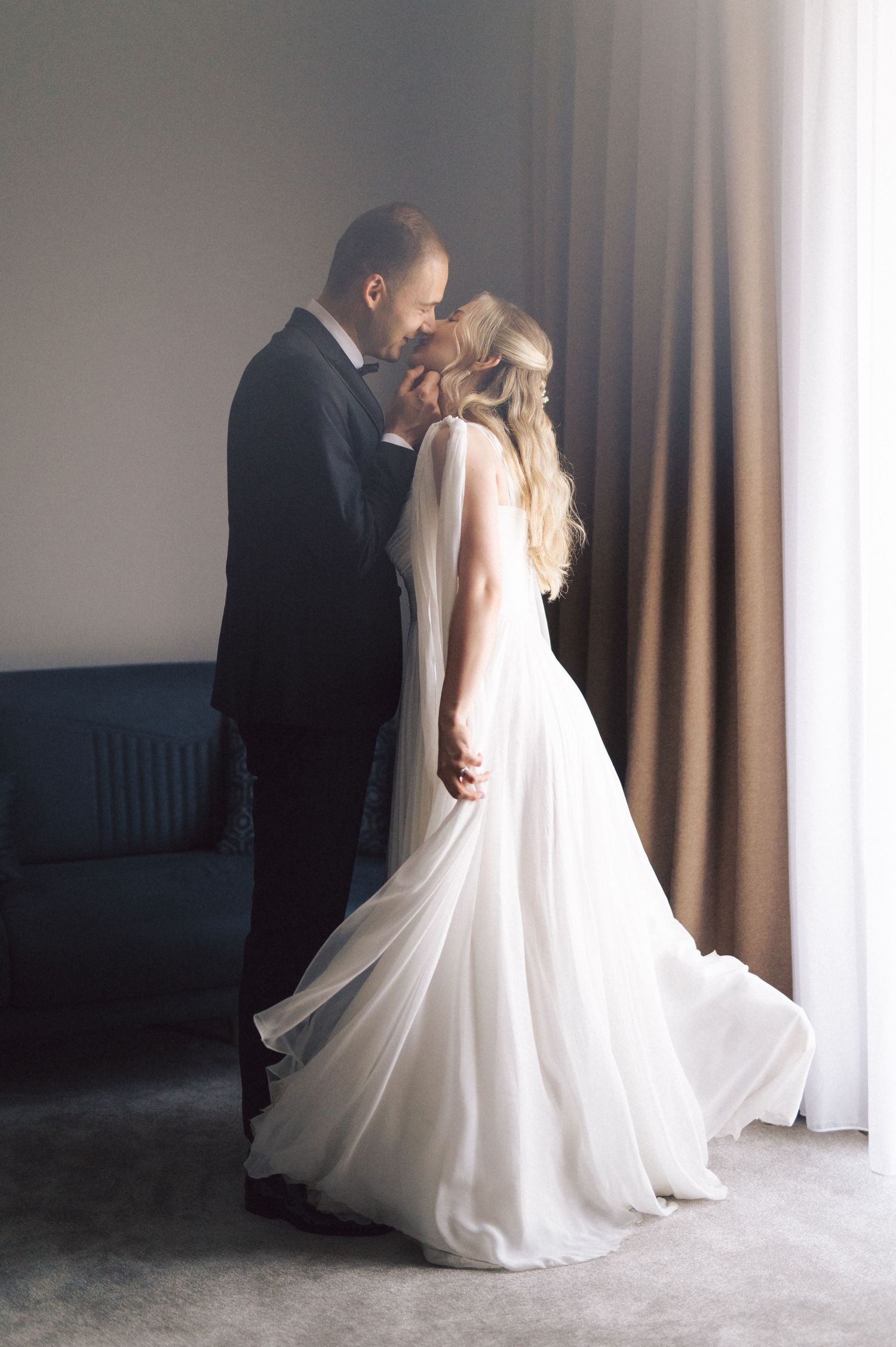 Ethereal wedding photo series shows couple in tender moments with flowing white dress and curtains.