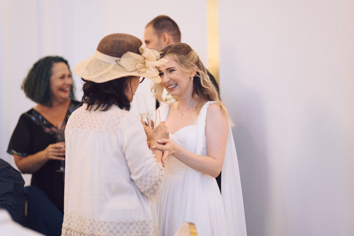 A collection of candid wedding moments showing guests hugging and celebrating in black and white photography.