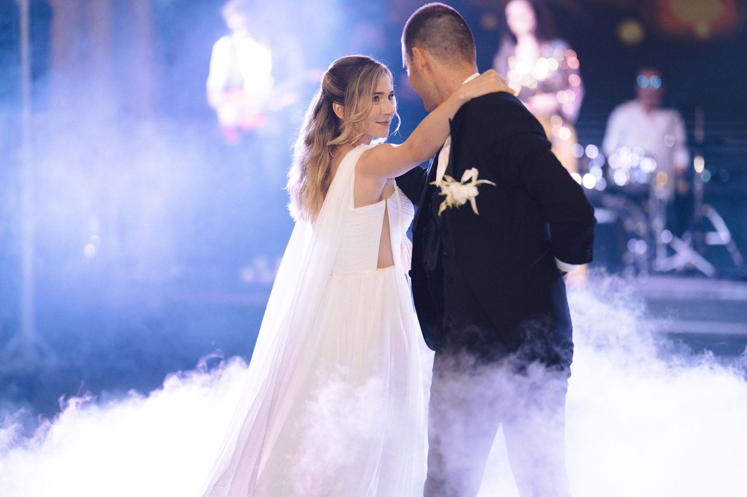 A romantic first dance between newlyweds surrounded by atmospheric fog effects at their wedding reception.