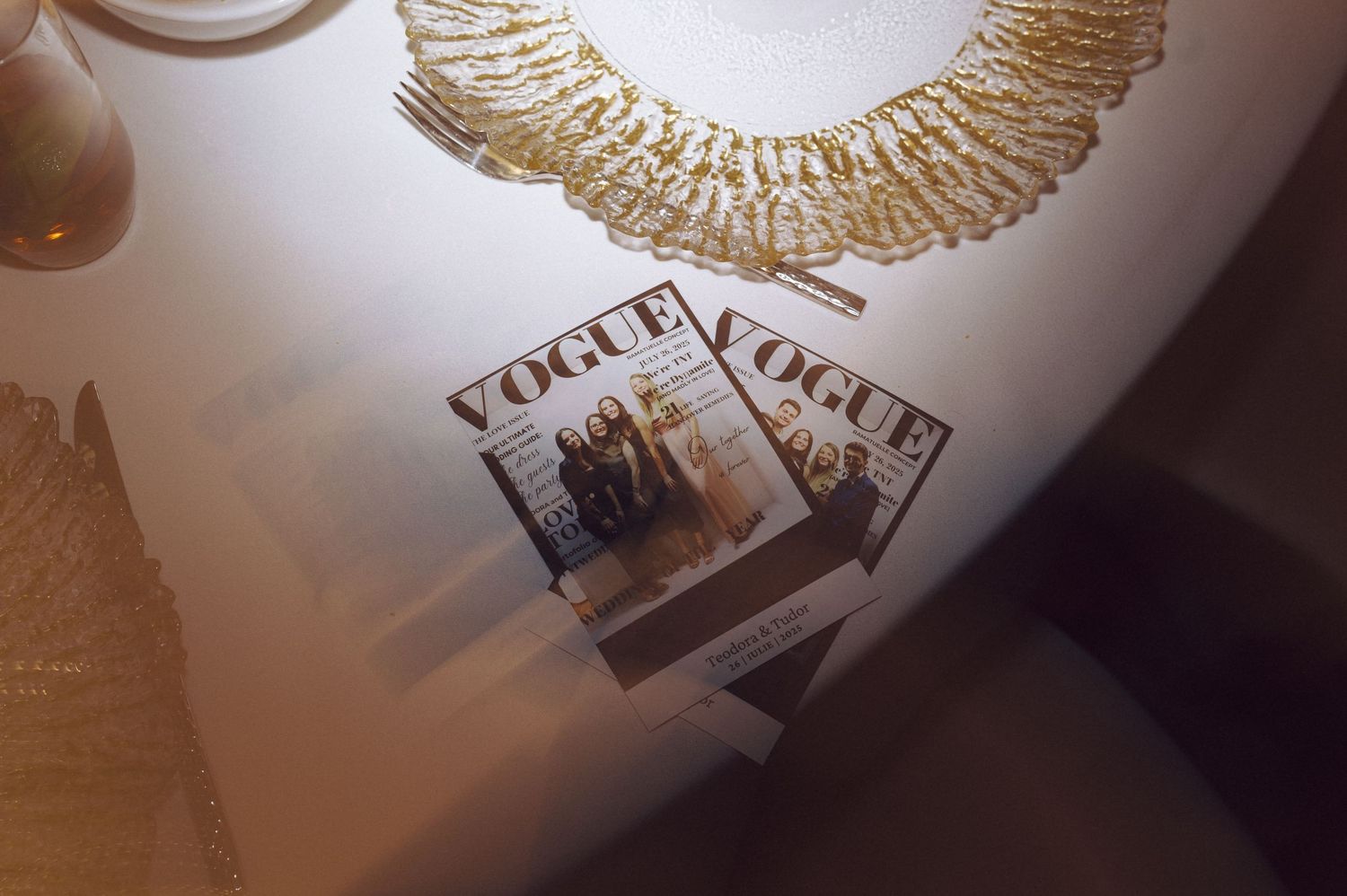 A vintage wedding invitation shows two intertwined golden rings and ornate wings design on a white background.