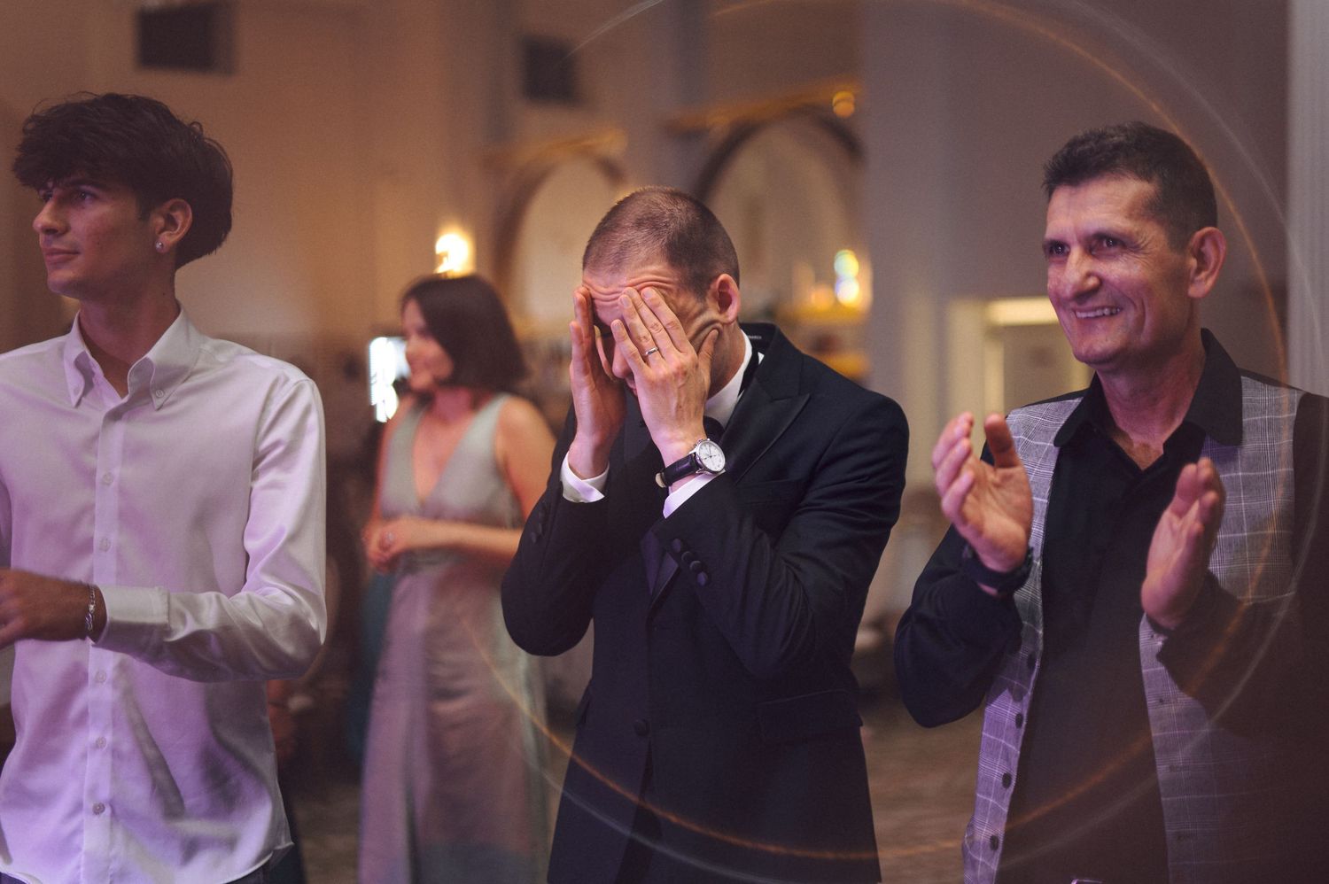 Wedding guests showing emotional reactions during reception celebrations.