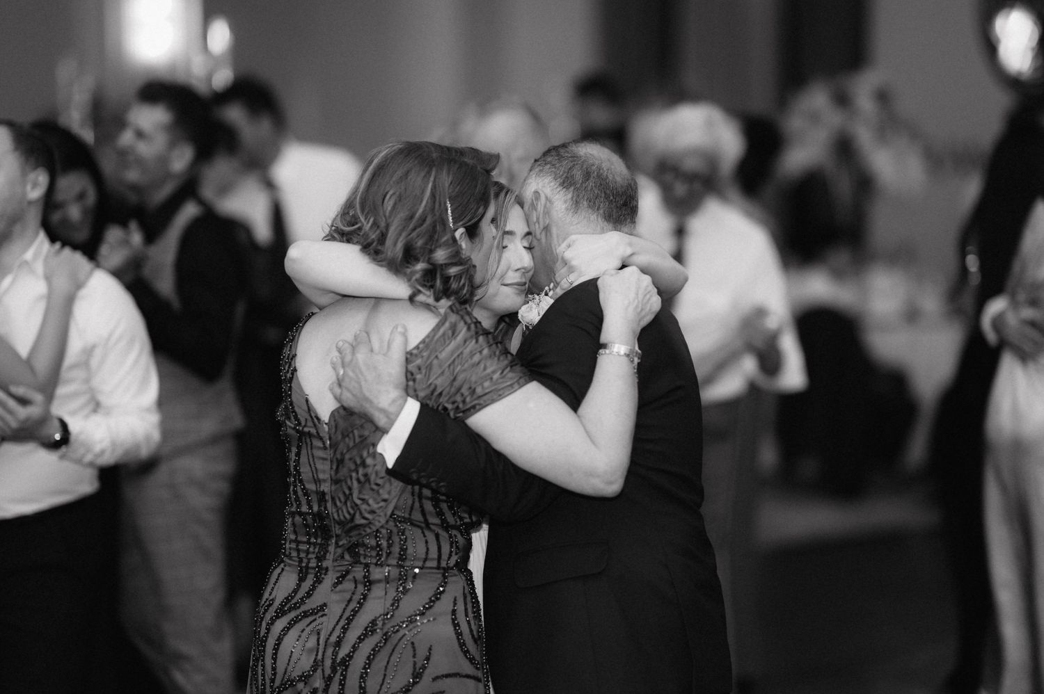Couples dance together in a romantic slow dance at an evening reception event.