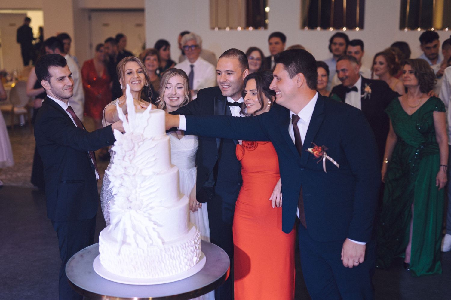 A series of wedding photographs showing party guests mingling and dancing at a reception celebration.