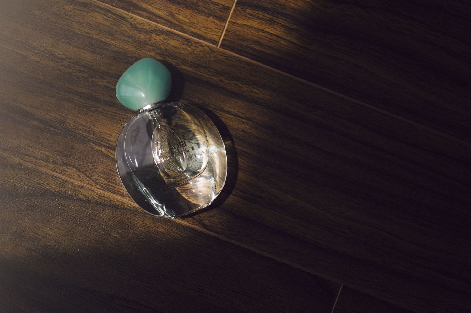 A vintage film camera with light meter mounted on a polished wooden table with dramatic lighting.
