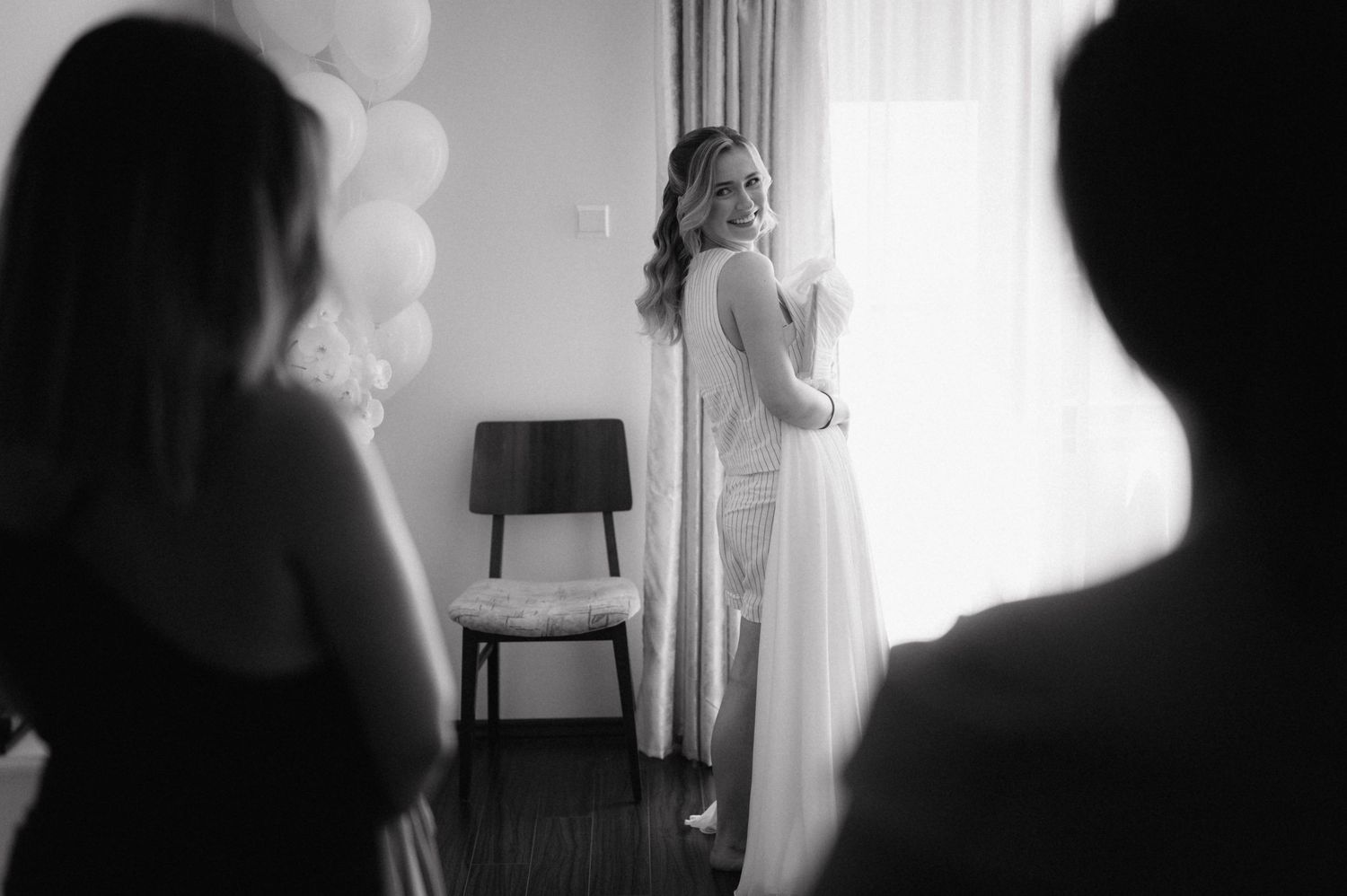 A black and white montage of five silhouettes standing near windows with dramatic lighting and curtains.