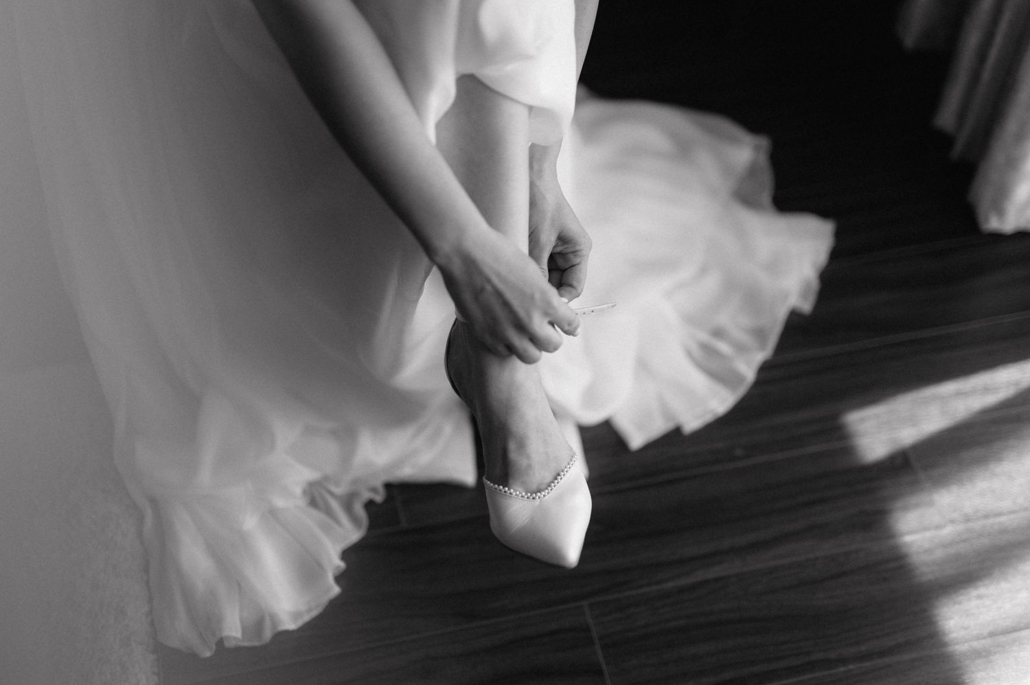 A gentle touch caring for a delicate white wedding dress as it hangs in preparation for a special day.