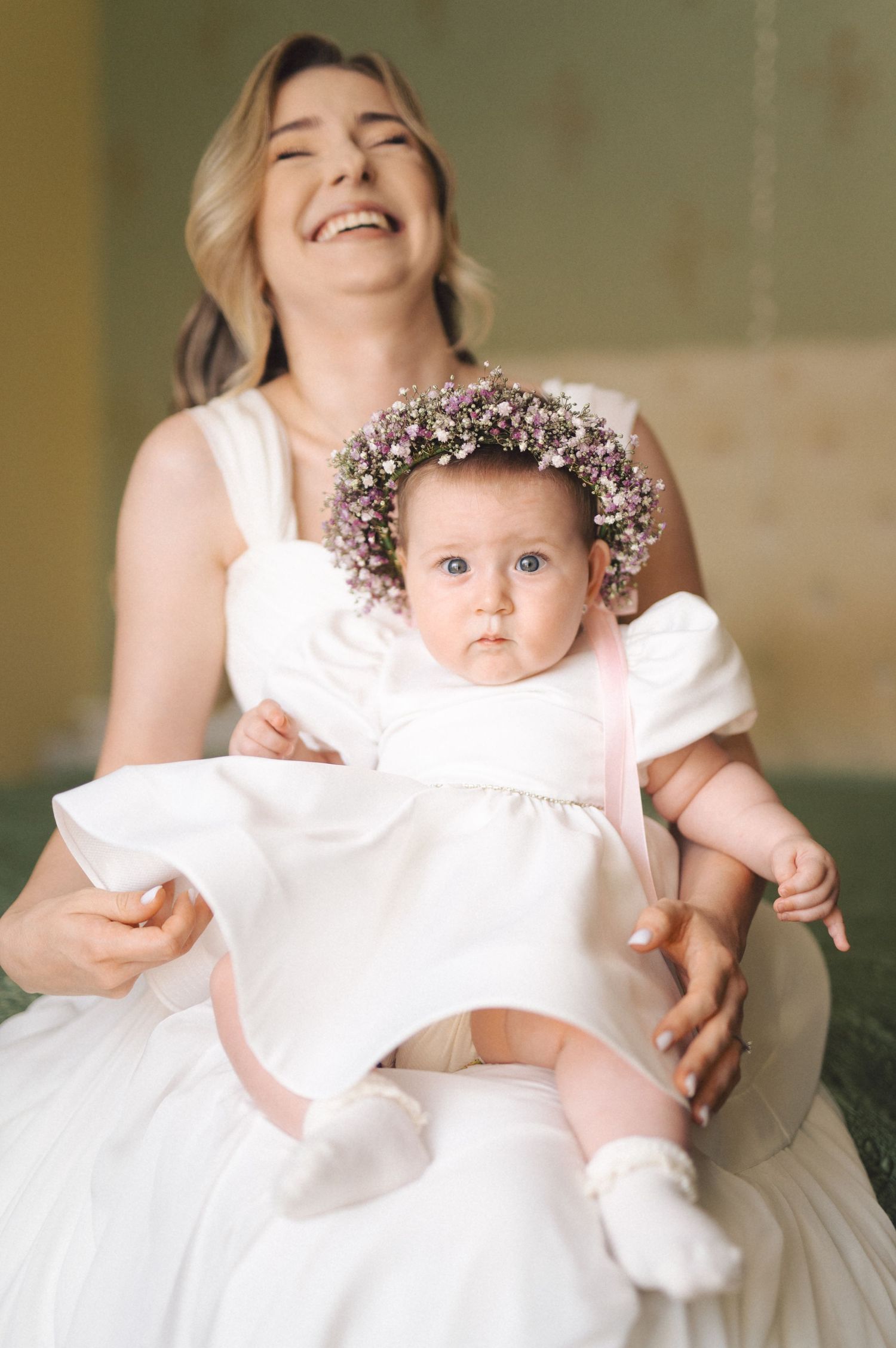 A series of candid photos showing a baby in a flowing white dress and floral headpiece during a portrait session.