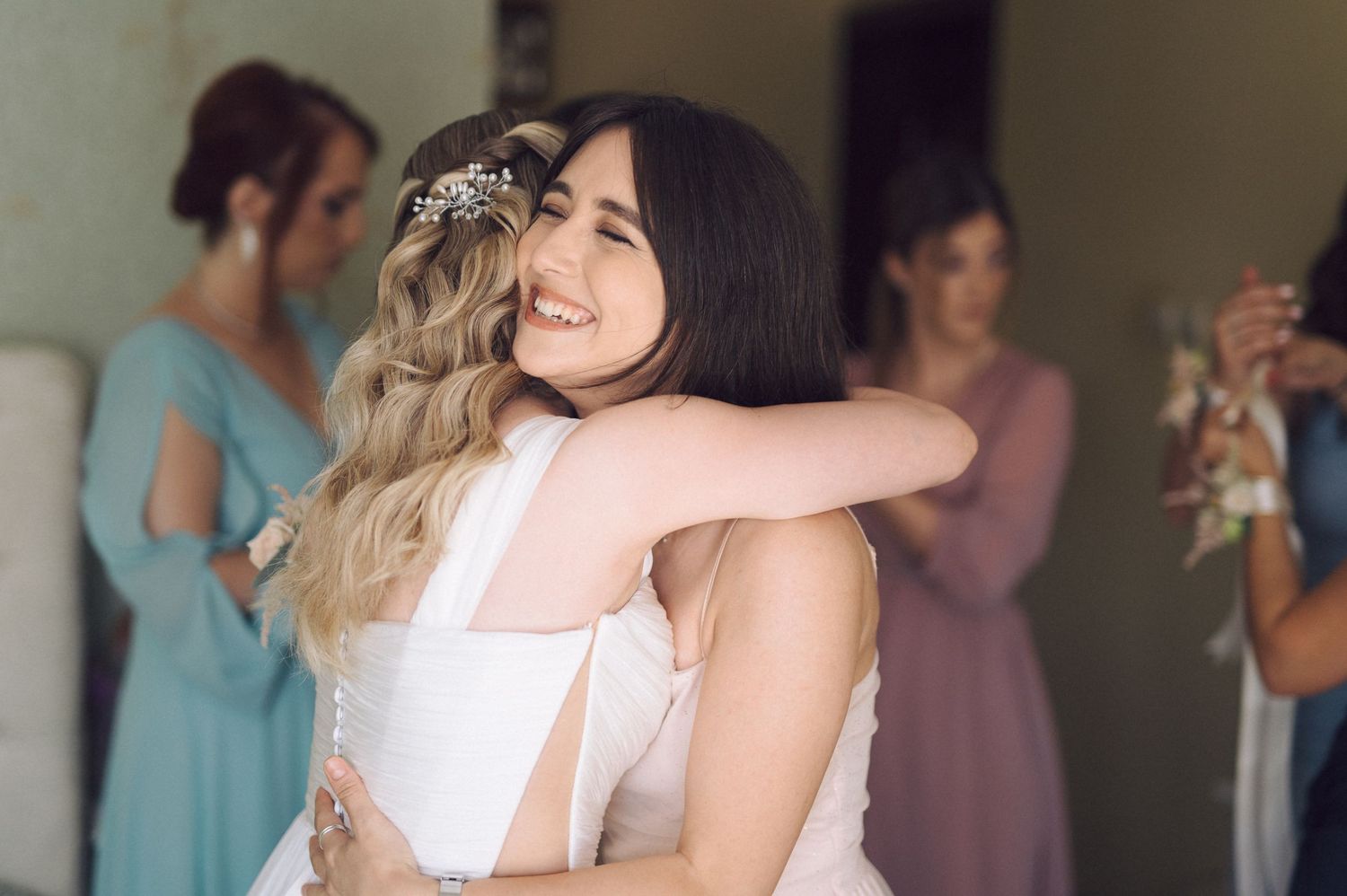 Wedding guests dance and embrace on a crowded dance floor during a reception celebration.
