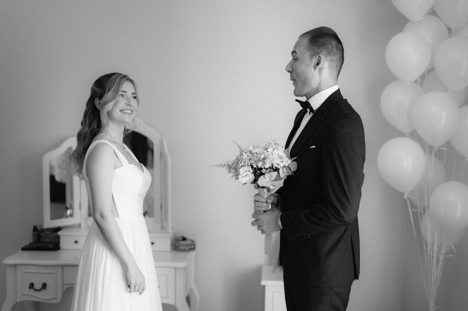 Wedding couple moments captured in romantic black and white photos with elegant balloons and formal attire.