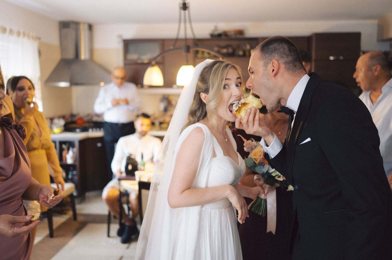 A couple shares a joyful moment while celebrating at an intimate indoor wedding reception gathering.