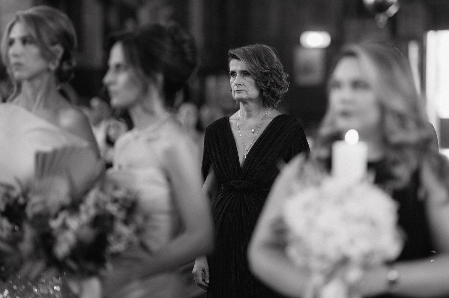 Black and white photo of a wedding celebration showing attendees in formal attire during an evening reception.