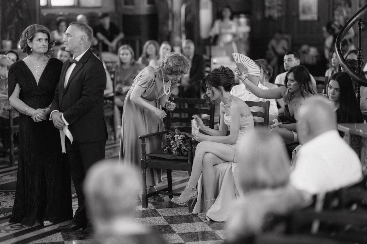 A black and white photograph of couples dancing at an elegant vintage social gathering in an indoor venue.